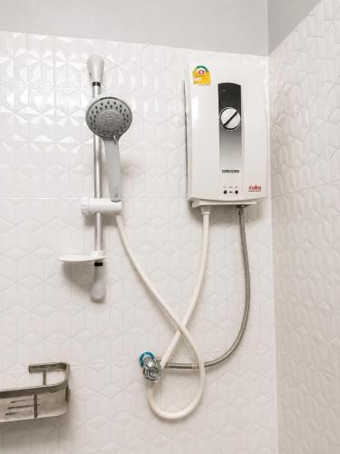 a bathroom with a shower with a hair dryer at Ban Loom Guesthouse & Weaving Workshop in Luang Prabang