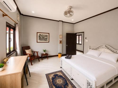a bedroom with a large white bed in a room at Ban Loom Guesthouse & Weaving Workshop in Luang Prabang