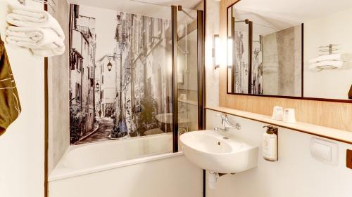 a bathroom with a sink and a mirror at Campanile NATURE - Moulins Avermes in Avermes