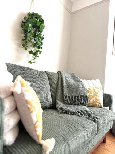 a living room with a green couch with pillows at Joshua House in Newquay
