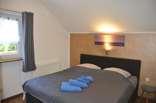 a bedroom with a bed with blue towels on it at Ferienwohnung Wildgatter in Grafenwiesen