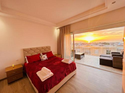 a bedroom with a bed and a large window at Ocean View Duplex & Golf, Taghazout Bay in Tamraght Ouzdar