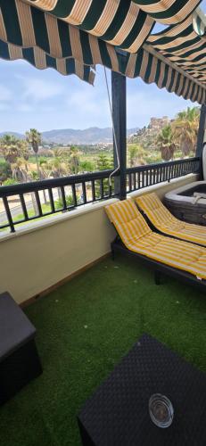 a balcony with a bench and a view of the mountains at Terraza al mar in Salobreña