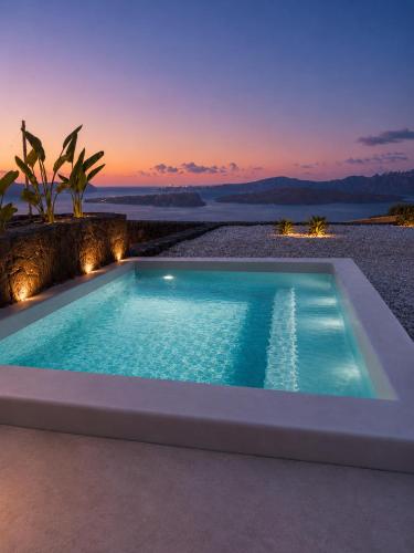 a swimming pool with a sunset in the background at Vespera Private Luxury Suites in Santorini
