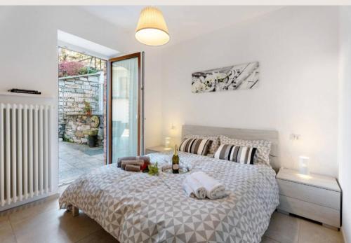 a white bedroom with a large bed and a window at Residenza Jasmine in Verbania