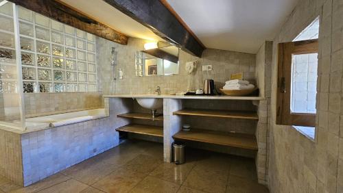 a bathroom with a sink and a bath tub at Hôtel la Fête en Provence in Vaison-la-Romaine