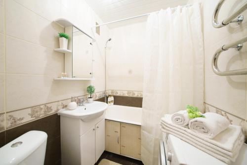 a bathroom with a sink and a toilet and a tub at PaulMarie Apartments on Oktyabrskaya in Bobruisk