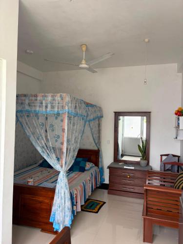 a bedroom with a bed with a canopy and a mirror at top sea view guest in Mirissa
