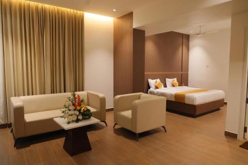 a hotel room with a bed and a couch and chairs at MOKSH SERENe in Shrīnagar