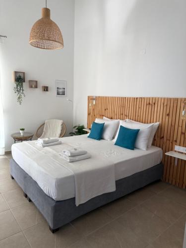 a bedroom with a large bed with blue pillows at Angelos Studios in Ilia