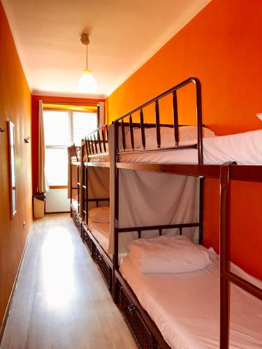 two bunk beds in a room with an orange wall at Let's Rock Party Hostel! Age Limit From 18 until 40! in Krakow