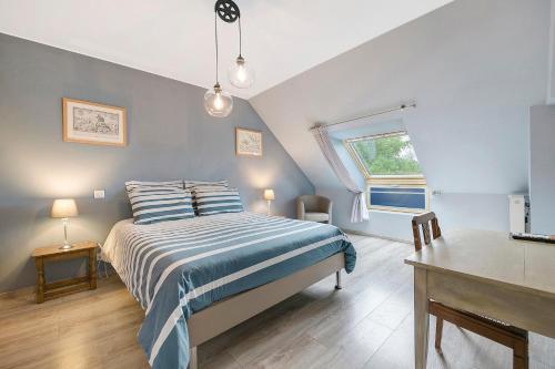 a bedroom with a bed and a desk and a window at Chambres D'hôtes - Les Vergers in Muneville-sur-Mer