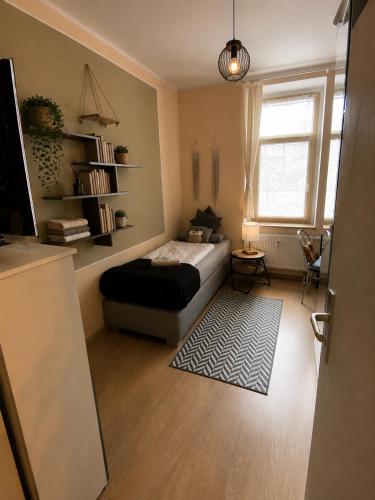 a living room with a bed and a window at Adam's Pension in Chemnitz