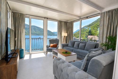 a living room with a couch and a large window at Apartments Krivokapic in Perast