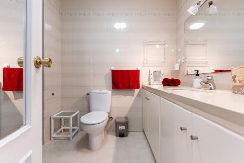 a white bathroom with a toilet and a sink at El Rey in Fuengirola