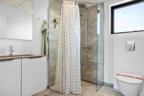 a bathroom with a shower with a toilet and a sink at LF12002-Spottrup-Molleparken-17 in Spottrup