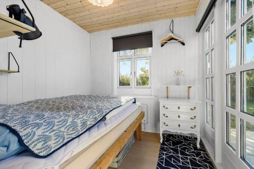a bedroom with a bed and a dresser and windows at 8566-Grenaa-Askevej-17 in Grenå