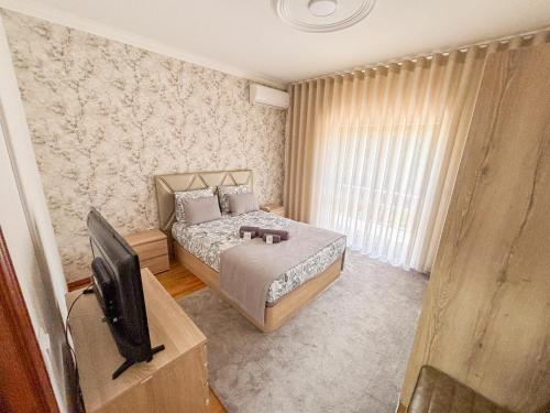 a bedroom with a bed and a flat screen tv at Abadia House - Geres in Geres
