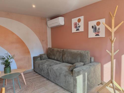a living room with a couch and a table at Les Terres Beaujolaises in Belleville-en-Beaujolais