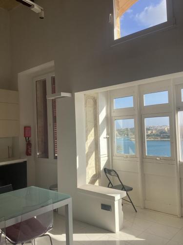 a living room with a glass table and windows at Apartment best Harbour view in Valletta