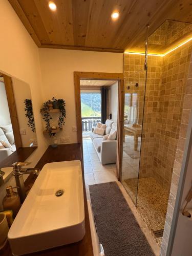 a bathroom with a sink and a glass shower at charmant studio à Morzine avec piscine privé in Morzine