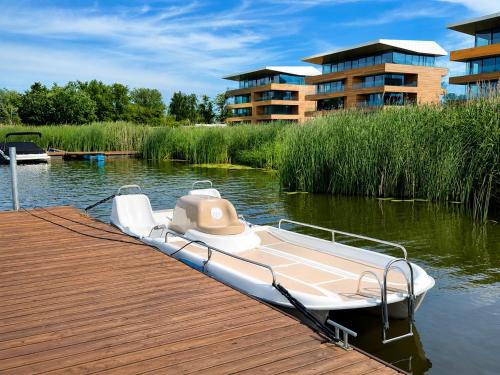 a boat tied up to a dock on the water at Zegrze Riva with the view in Zegrze Południowe