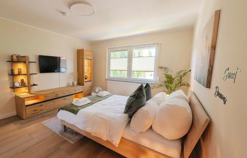 a bedroom with a bed with pillows and a television at Stadtwohnung mit Flair in Recklinghausen
