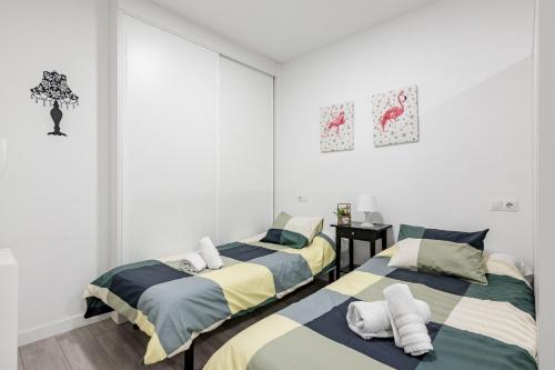 two beds in a room with white walls at Studio 1 Soto Parking Renfe in Torrejón de Ardoz