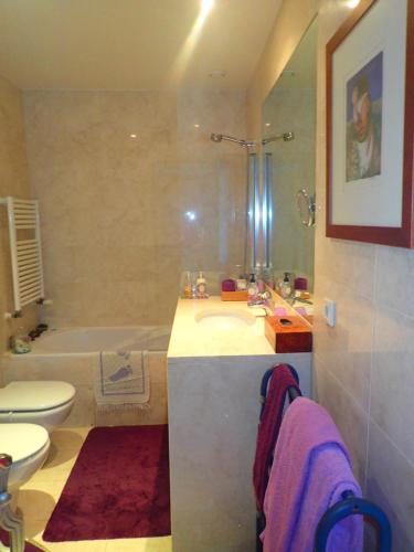 a bathroom with a sink and a tub and a toilet at LxRiverside Suite Apartment in Lisbon