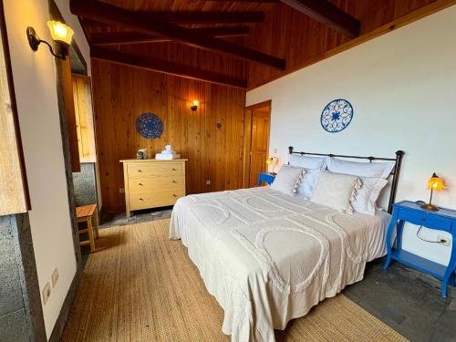a bedroom with a bed and a wooden wall at Casa da Terra Alta in Santo Amaro