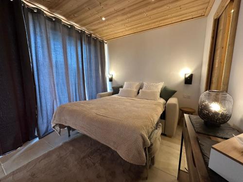 a bedroom with a bed and a large window at charmant studio à Morzine avec piscine privé in Morzine