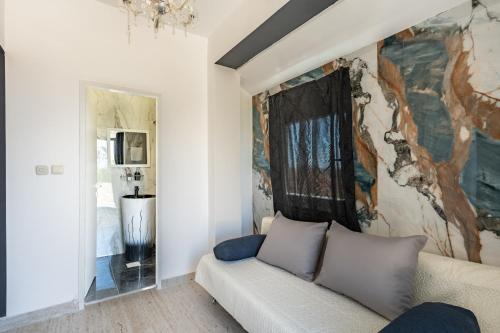 a living room with a couch and a painting on the wall at Vila Martina in Novalja