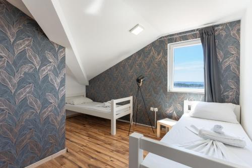 a bedroom with two beds and a window at Vila Martina in Novalja