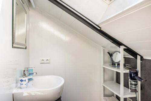 a white bathroom with a sink and a mirror at Elfenwinkel am See in Gartow