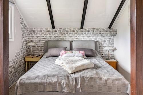 a bedroom with a bed and a brick wall at Elfenwinkel am See in Gartow