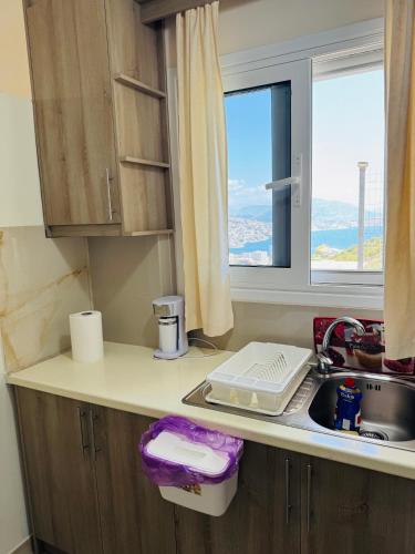 a kitchen counter with a sink and a window at Vitamin Sea in Sarandë