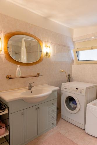 a bathroom with a sink and a washing machine at La Bomboniera di Anna in Erba