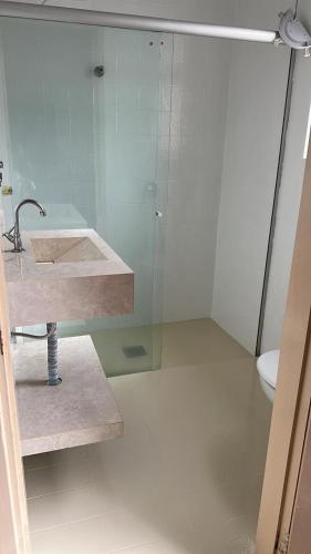 a bathroom with a sink and a glass shower at Bento palace hotel in Assis