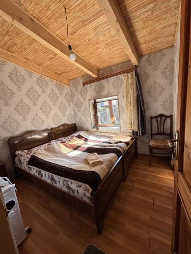 a bedroom with a bed and a chair in it at Old House in Ushguli