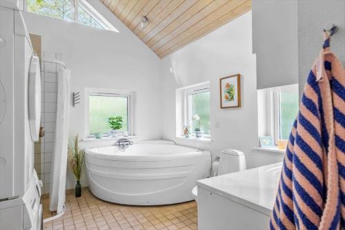 a white bathroom with a large tub and a sink at 8552-Grenaa-Polderrevsvej-17 in Grenå
