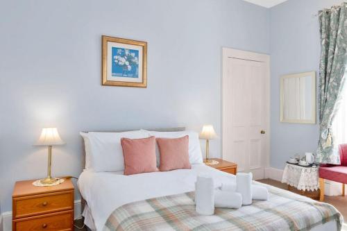 a bedroom with a large white bed with two lamps at GuestReady - Links View in Edinburgh