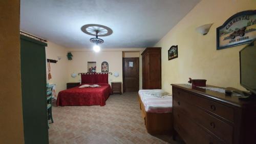 a bedroom with a red bed and a dresser at Agriturismo Podere dei Venti in Piancastagnaio