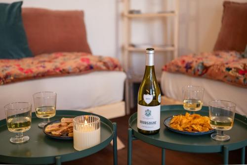 a bottle of wine and two tables with food and wine glasses at a charming little apartment in Cluny