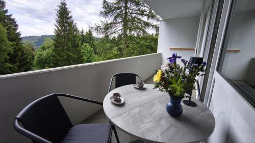 a table with a vase of flowers on a balcony at HochDrei - Hahnenklee in Goslar