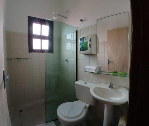 a bathroom with a toilet and a sink and a shower at Zaya Mar Pousada in Bertioga