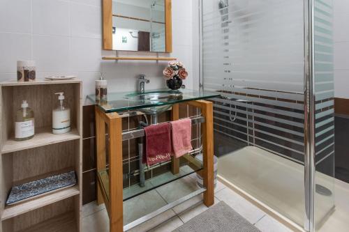 a bathroom with a glass sink and a shower at Demeure Olea in Chérac