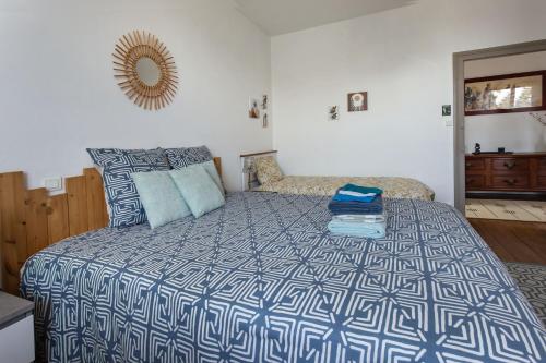 a bedroom with a bed with a blue and white comforter at Demeure Olea in Chérac