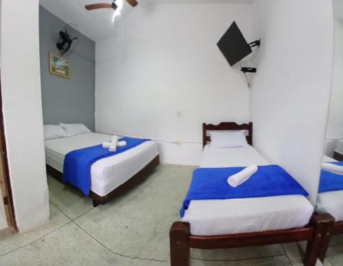 two beds in a room with blue and white at Zaya Mar Pousada in Bertioga