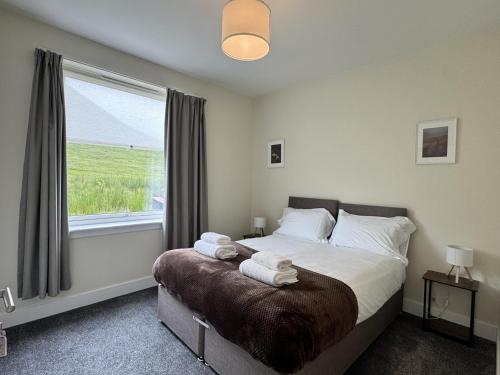 a bedroom with a bed with towels on it at Auch - Trail Cabins in Bridge of Orchy
