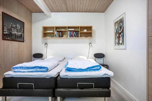 two twin beds in a room with a book shelf at LF12011-Spottrup-Vadumvej-1-E in Spottrup
